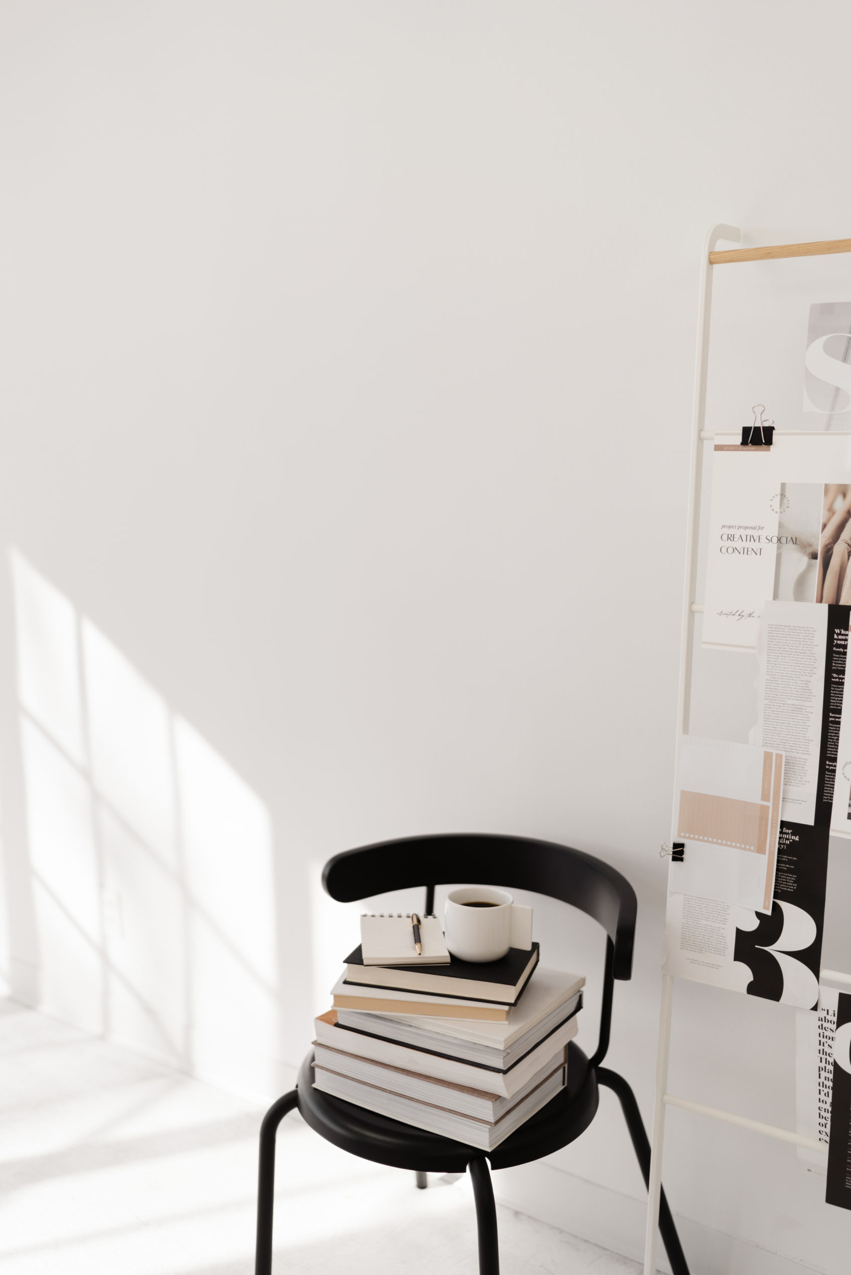 pinterest books sitting on chair while designer works on website